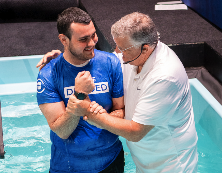 A pastor embraces a man in anticipation of baptising him.