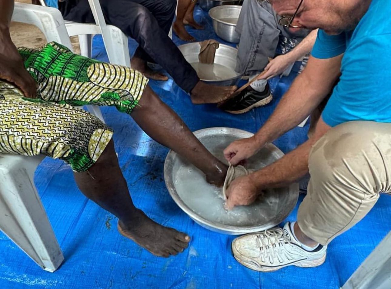 Man washes the feet of someone he is serving for a mission trip.